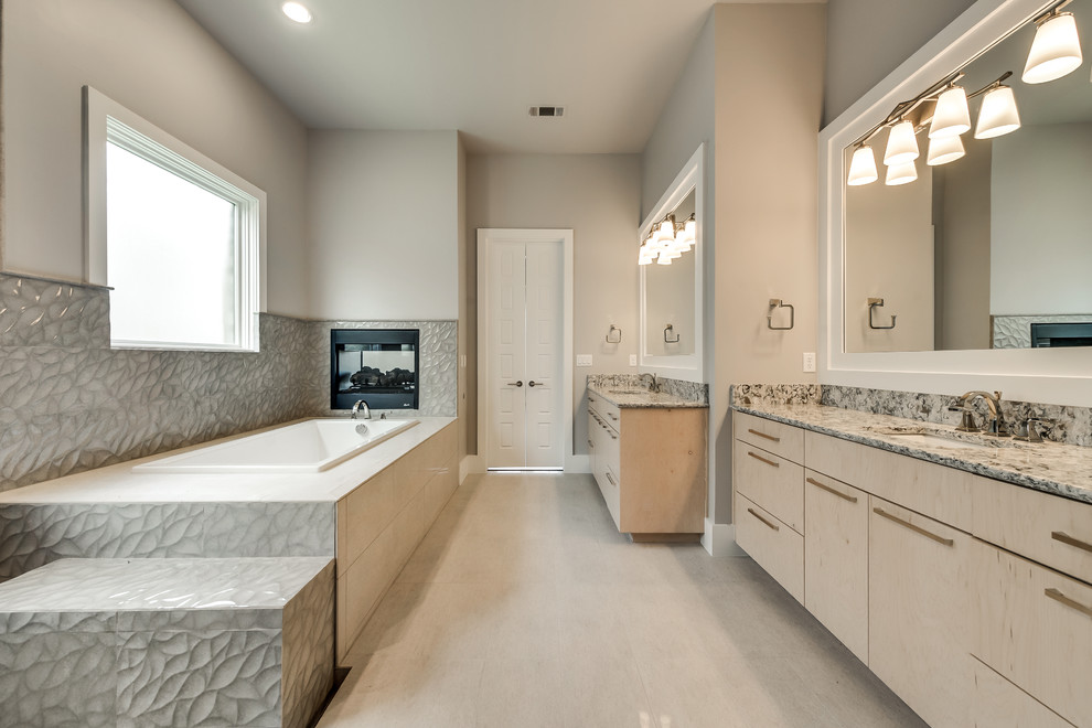 Inspiration for a large traditional ensuite bathroom in Dallas with flat-panel cabinets, light wood cabinets, a built-in bath, a corner shower, beige tiles, glass sheet walls, engineered stone worktops and a hinged door.