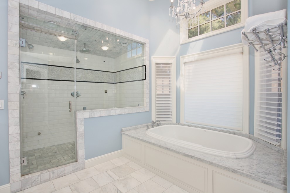 Klassisk inredning av ett badrum, med ett platsbyggt badkar, en dusch i en alkov och vit kakel