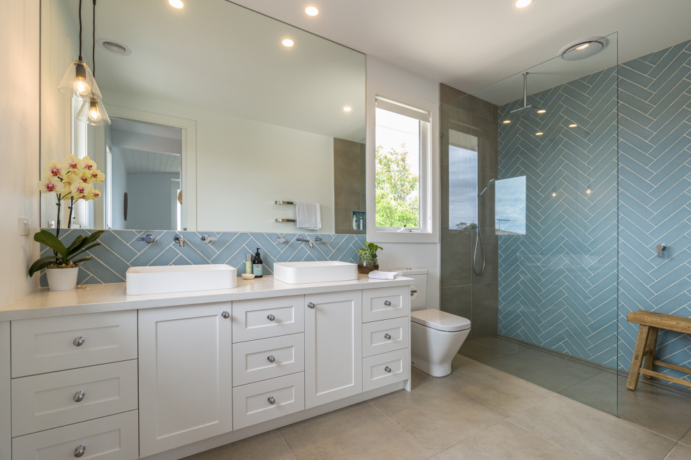 Modelo de cuarto de baño a medida rústico con puertas de armario blancas, baldosas y/o azulejos azules, lavabo encastrado, suelo beige, ducha abierta y encimeras blancas