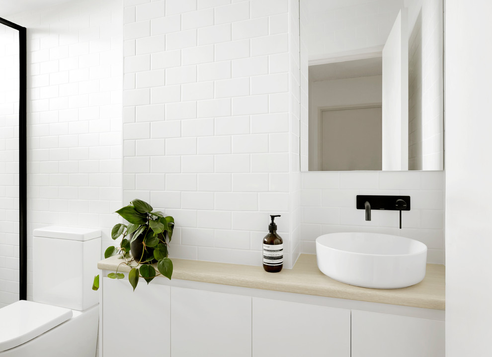 Foto på ett litet skandinaviskt badrum, med luckor med lamellpanel, vita skåp, en kantlös dusch, vit kakel, tunnelbanekakel, klinkergolv i keramik, laminatbänkskiva, grått golv och dusch med gångjärnsdörr