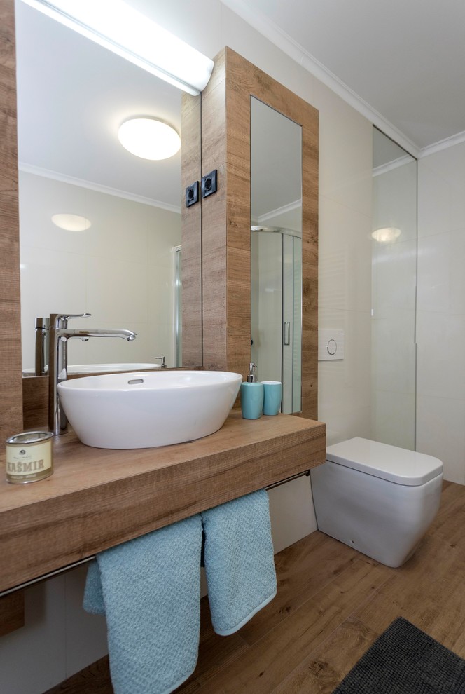 Стильный дизайн: маленькая главная ванная комната в скандинавском стиле с унитазом-моноблоком, белой плиткой, керамической плиткой, белыми стенами, светлым паркетным полом, раковиной с пьедесталом и коричневым полом для на участке и в саду - последний тренд