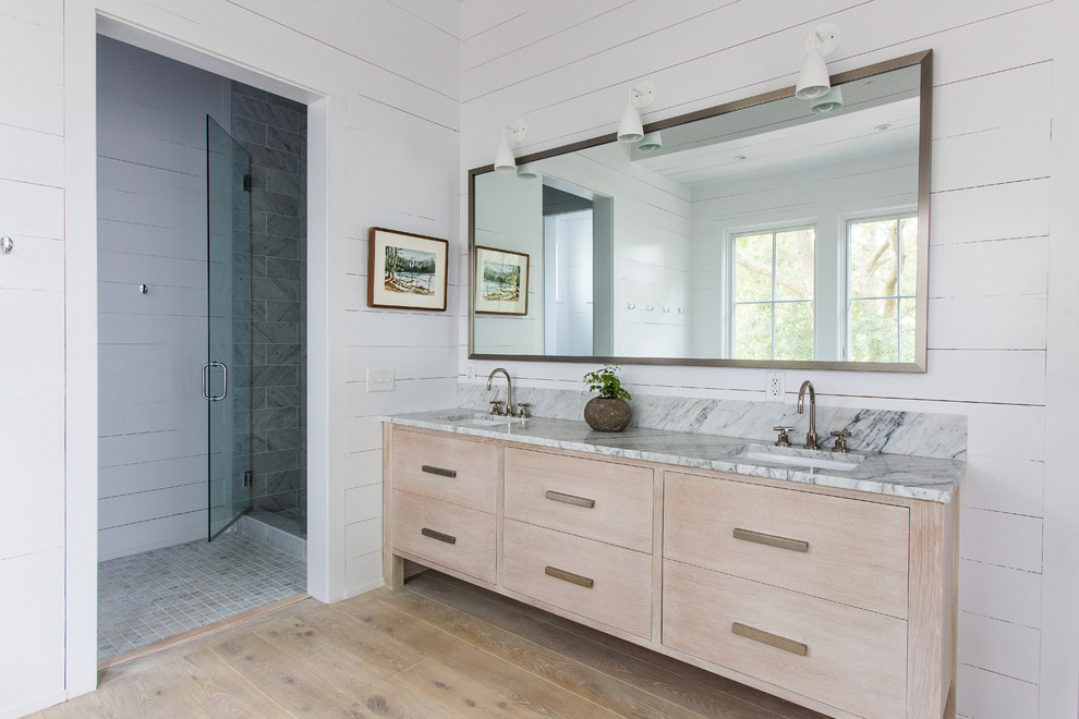 Diseño de cuarto de baño escandinavo con lavabo bajoencimera, armarios con paneles lisos, puertas de armario de madera clara, encimera de mármol, ducha empotrada, paredes blancas y suelo de madera en tonos medios
