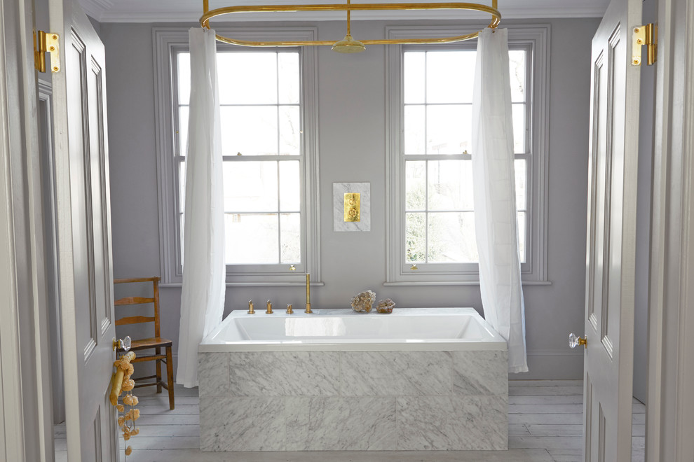 Imagen de cuarto de baño nórdico con bañera encastrada, baldosas y/o azulejos blancos, paredes grises, combinación de ducha y bañera y suelo de madera pintada