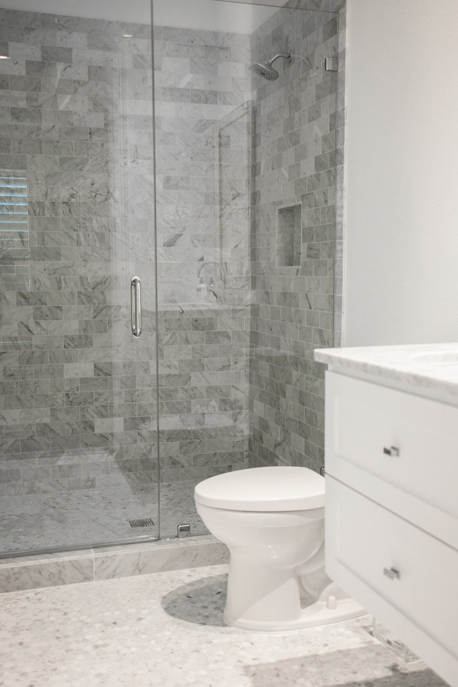 This is an example of a small scandinavian shower room bathroom in Houston with shaker cabinets, white cabinets, an alcove shower, a one-piece toilet, grey tiles, marble tiles, white walls, pebble tile flooring, a submerged sink, marble worktops, grey floors, grey worktops and a hinged door.