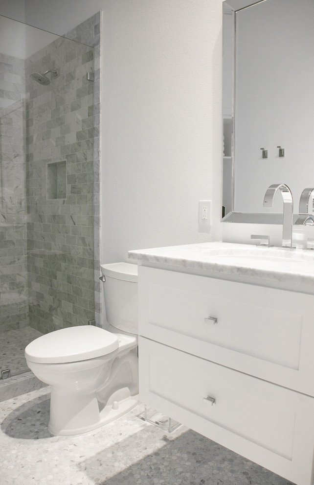 Photo of a small scandi shower room bathroom in Houston with shaker cabinets, white cabinets, an alcove shower, a one-piece toilet, grey tiles, marble tiles, white walls, pebble tile flooring, a submerged sink, marble worktops, grey floors and grey worktops.