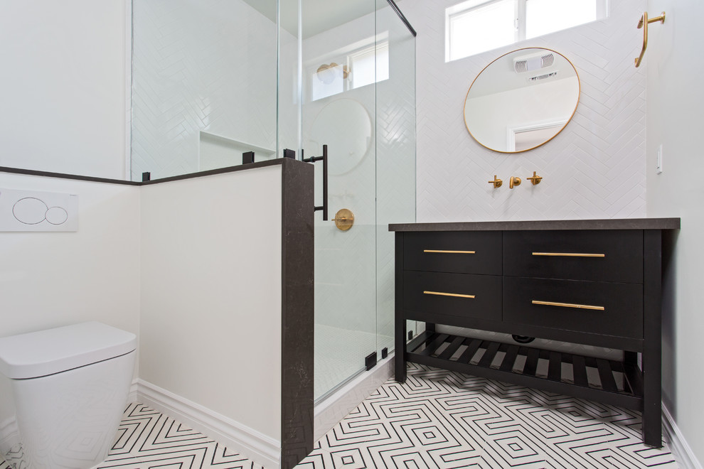 ロサンゼルスにある高級な中くらいな北欧スタイルのおしゃれなマスターバスルーム (フラットパネル扉のキャビネット、黒いキャビネット、コーナー設置型シャワー、壁掛け式トイレ、白いタイル、サブウェイタイル、白い壁、セメントタイルの床、アンダーカウンター洗面器、クオーツストーンの洗面台、開き戸のシャワー) の写真
