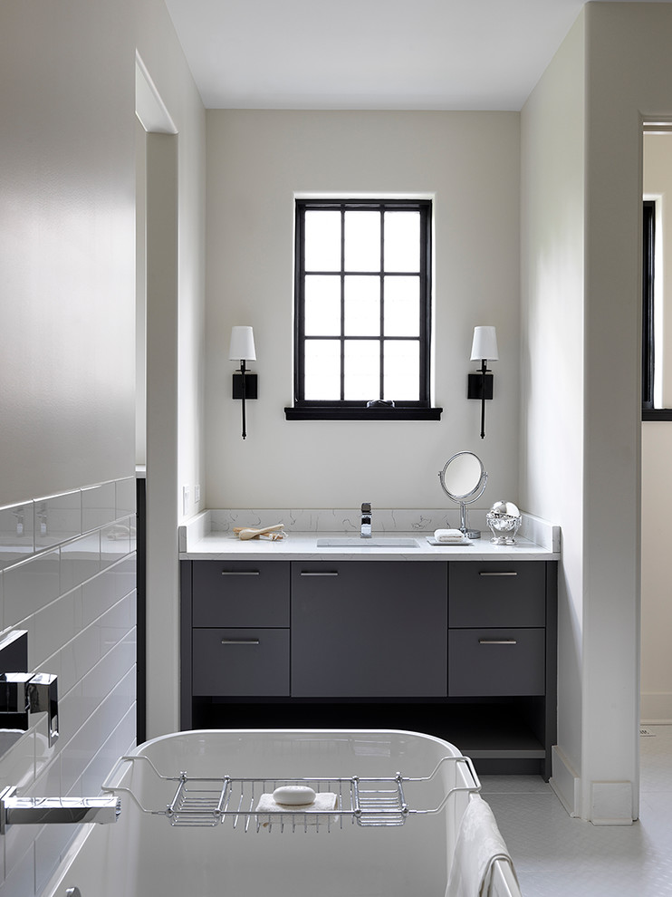 シカゴにある北欧スタイルのおしゃれな浴室 (フラットパネル扉のキャビネット、グレーのキャビネット、置き型浴槽、白いタイル、サブウェイタイル、グレーの壁、モザイクタイル、アンダーカウンター洗面器、白い床、白い洗面カウンター) の写真