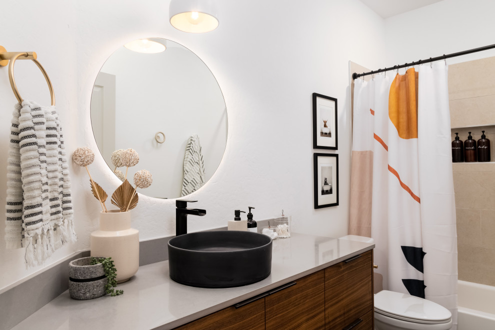 Nordisk inredning av ett grå grått badrum, med släta luckor, skåp i mörkt trä, ett badkar i en alkov, en dusch/badkar-kombination, beige kakel, vita väggar, ett fristående handfat och dusch med duschdraperi