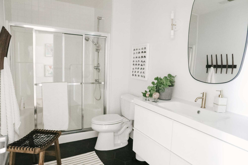 Example of a mid-sized danish kids' porcelain tile, black floor and single-sink sliding shower door design in Other with flat-panel cabinets, white cabinets, a one-piece toilet, white walls, an integrated sink, white countertops and a floating vanity