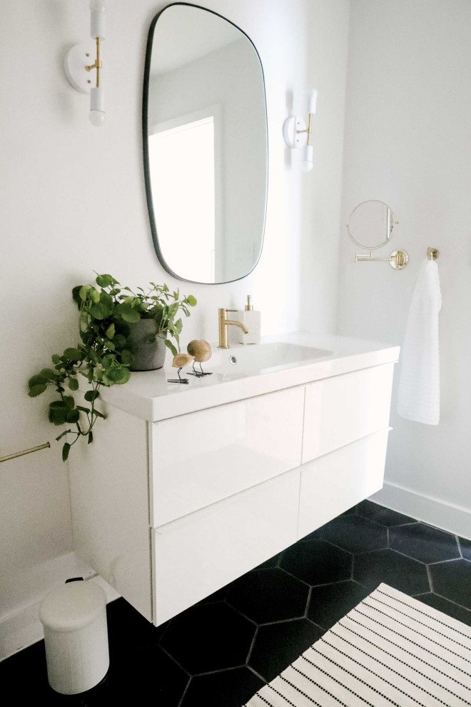 Foto på ett mellanstort minimalistiskt vit badrum för barn, med släta luckor, vita skåp, en toalettstol med hel cisternkåpa, vita väggar, klinkergolv i porslin, ett integrerad handfat, svart golv och dusch med skjutdörr