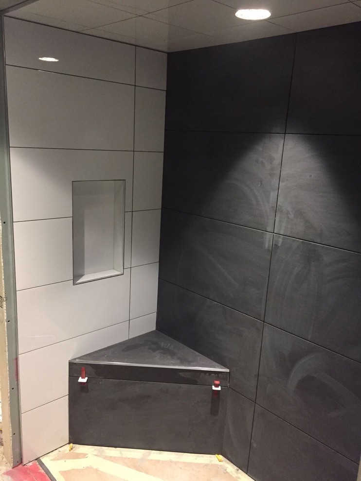 На фото: ванная комната среднего размера в стиле модернизм с черной плиткой, душевой кабиной, открытым душем и угловым душем с