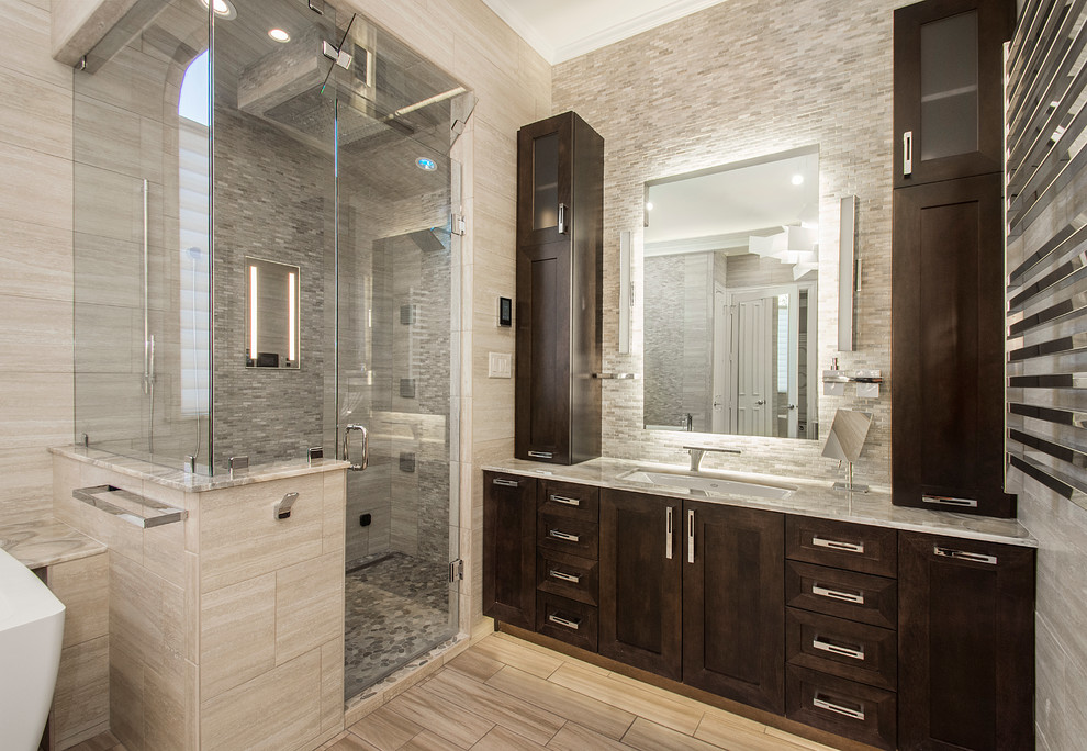 Large traditional ensuite bathroom in Dallas with shaker cabinets, dark wood cabinets, a freestanding bath, a corner shower, beige tiles, porcelain tiles, beige walls, porcelain flooring, a submerged sink and onyx worktops.