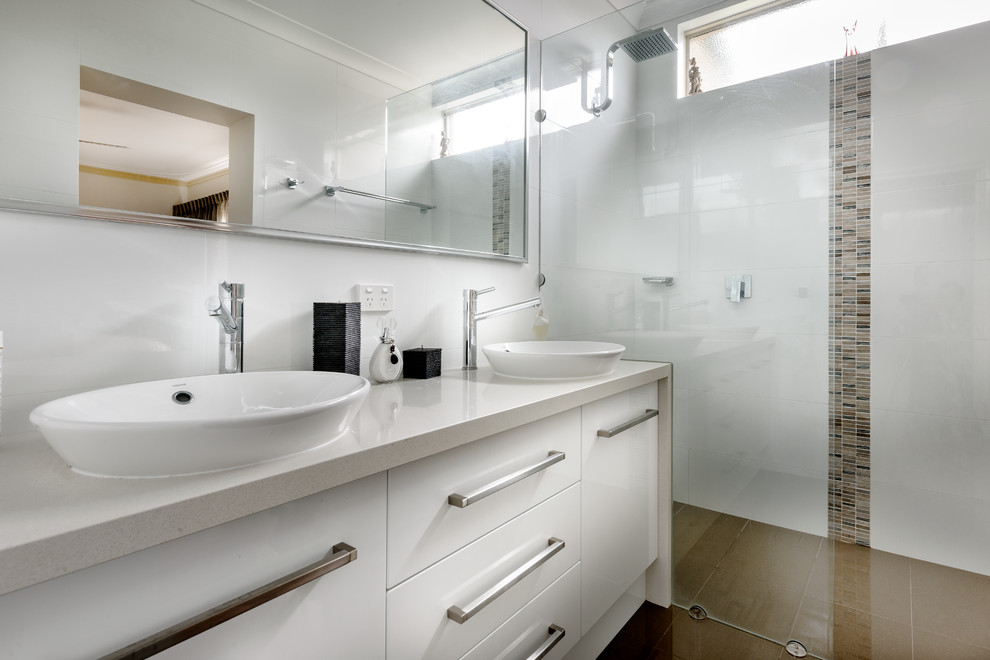 Inspiration för mellanstora moderna badrum, med ett fristående handfat, luckor med infälld panel, vita skåp, bänkskiva i akrylsten, en kantlös dusch, vit kakel, keramikplattor och vita väggar