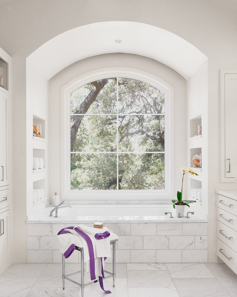 Modernes Badezimmer mit weißen Schränken, Badewanne in Nische und Wandnische in Austin