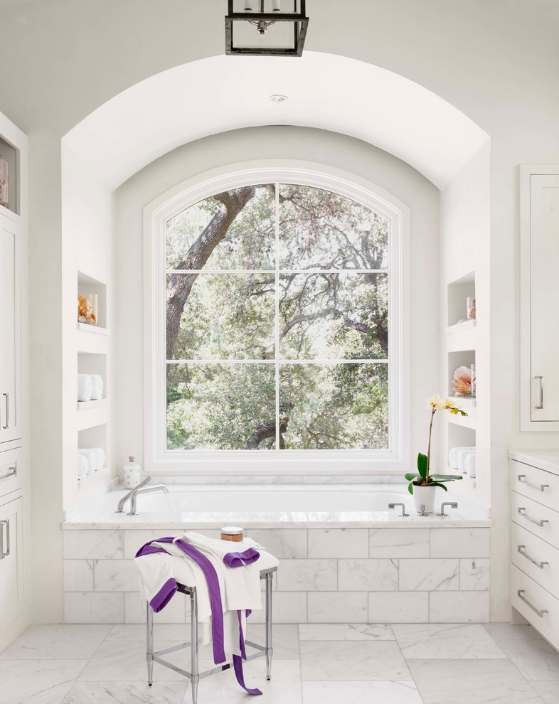 オースティンにある地中海スタイルのおしゃれな浴室 (シェーカースタイル扉のキャビネット、白いキャビネット、アルコーブ型浴槽、白いタイル、白い壁、大理石の床) の写真