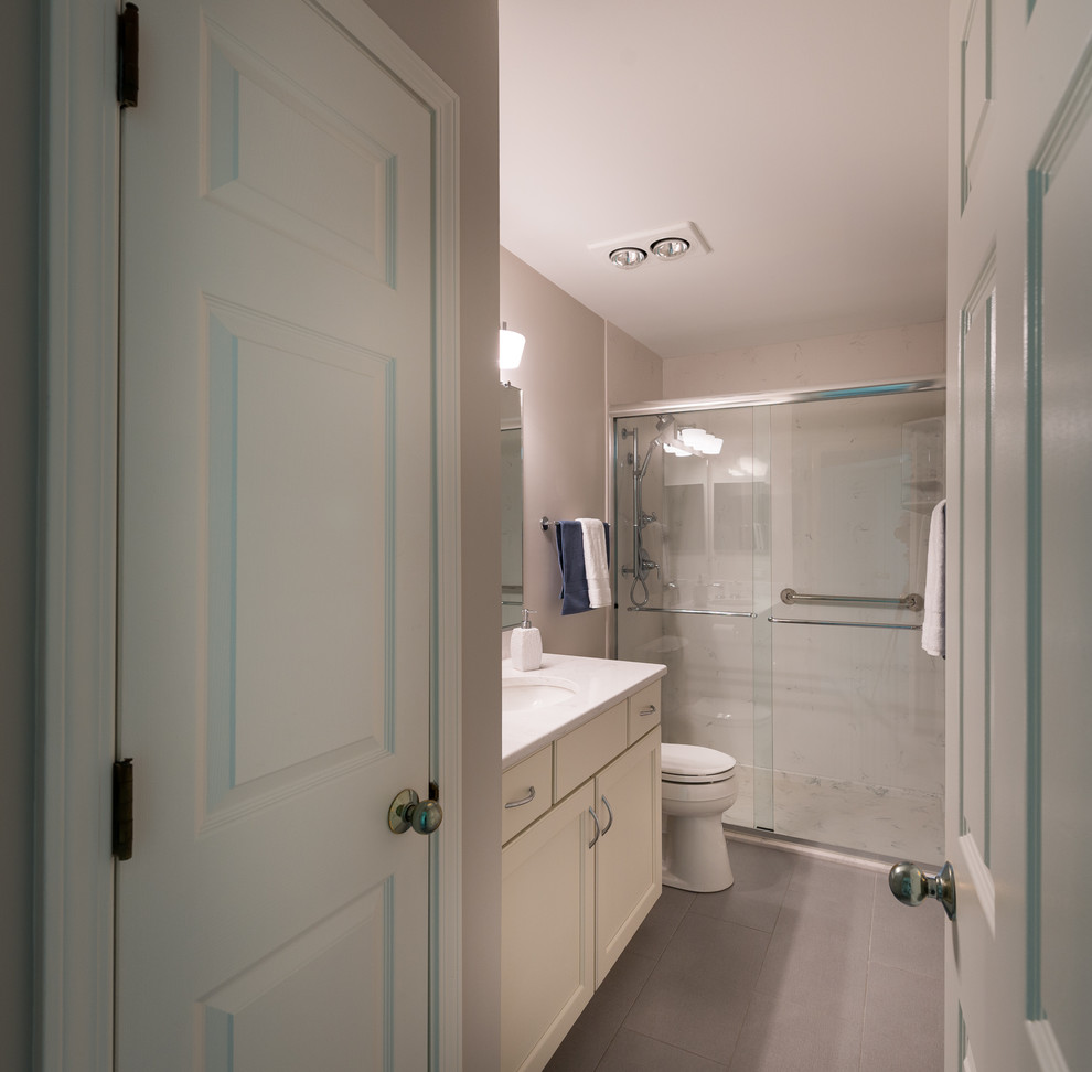 Пример оригинального дизайна: маленькая ванная комната в стиле неоклассика (современная классика) с фасадами с утопленной филенкой, двойным душем, раздельным унитазом, серой плиткой, серыми стенами, полом из керамогранита, душевой кабиной, врезной раковиной, столешницей из искусственного кварца, серым полом, душем с раздвижными дверями, светлыми деревянными фасадами и плиткой из листового камня для на участке и в саду
