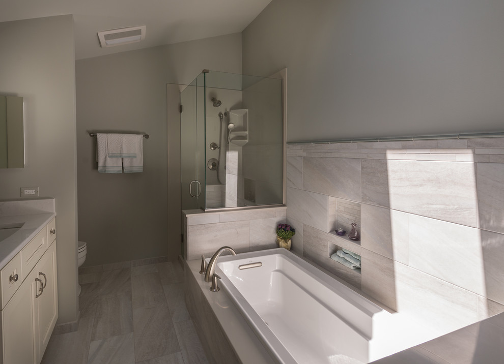 На фото: большая главная ванная комната в стиле неоклассика (современная классика) с фасадами с утопленной филенкой, накладной ванной, двойным душем, раздельным унитазом, зеленой плиткой, керамогранитной плиткой, серыми стенами, полом из керамогранита, врезной раковиной, столешницей из искусственного кварца, серым полом, душем с распашными дверями и светлыми деревянными фасадами с