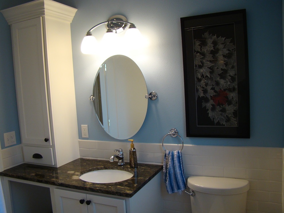 This is an example of a traditional bathroom in Seattle with a submerged sink, shaker cabinets, white cabinets, granite worktops, an alcove bath, a shower/bath combination, a two-piece toilet, white tiles and metro tiles.