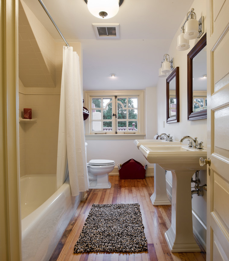 Design ideas for a medium sized rural family bathroom in Philadelphia with a pedestal sink, a freestanding bath, a shower/bath combination, a two-piece toilet, beige tiles, metro tiles, white walls and light hardwood flooring.