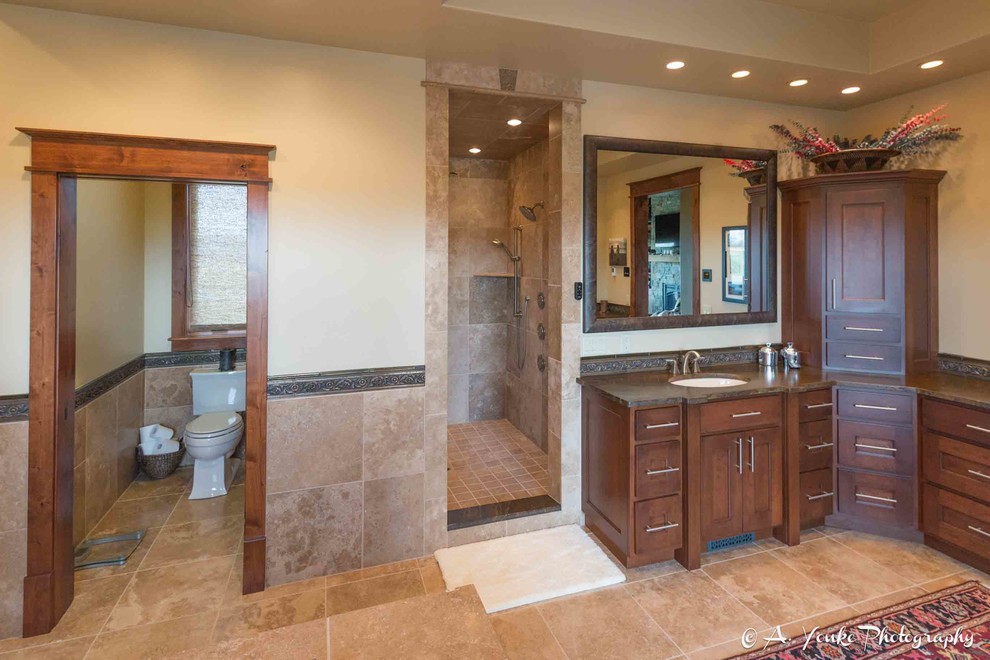 Inspiration for a large rustic master beige tile, brown tile and ceramic tile travertine floor bathroom remodel in Other with shaker cabinets, dark wood cabinets, beige walls, an undermount sink and soapstone countertops