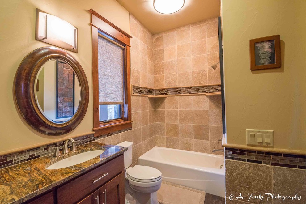 Пример оригинального дизайна: ванная комната среднего размера в стиле рустика с фасадами в стиле шейкер, фасадами цвета дерева среднего тона, ванной в нише, душем над ванной, унитазом-моноблоком, бежевой плиткой, коричневой плиткой, серой плиткой, керамической плиткой, желтыми стенами, полом из сланца, душевой кабиной, врезной раковиной и столешницей из гранита