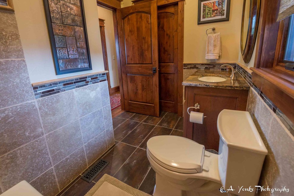 Idées déco pour une salle d'eau montagne en bois brun de taille moyenne avec un placard à porte shaker, WC à poser, un carrelage beige, un carrelage marron, un carrelage gris, des carreaux de céramique, un mur jaune, un sol en ardoise, un lavabo encastré et un plan de toilette en granite.