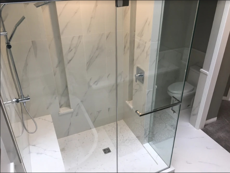 Design ideas for a large classic ensuite bathroom in Calgary with recessed-panel cabinets, grey cabinets, a freestanding bath, a corner shower, a two-piece toilet, white tiles, marble tiles, grey walls, marble flooring, a submerged sink, marble worktops, white floors, a sliding door and white worktops.