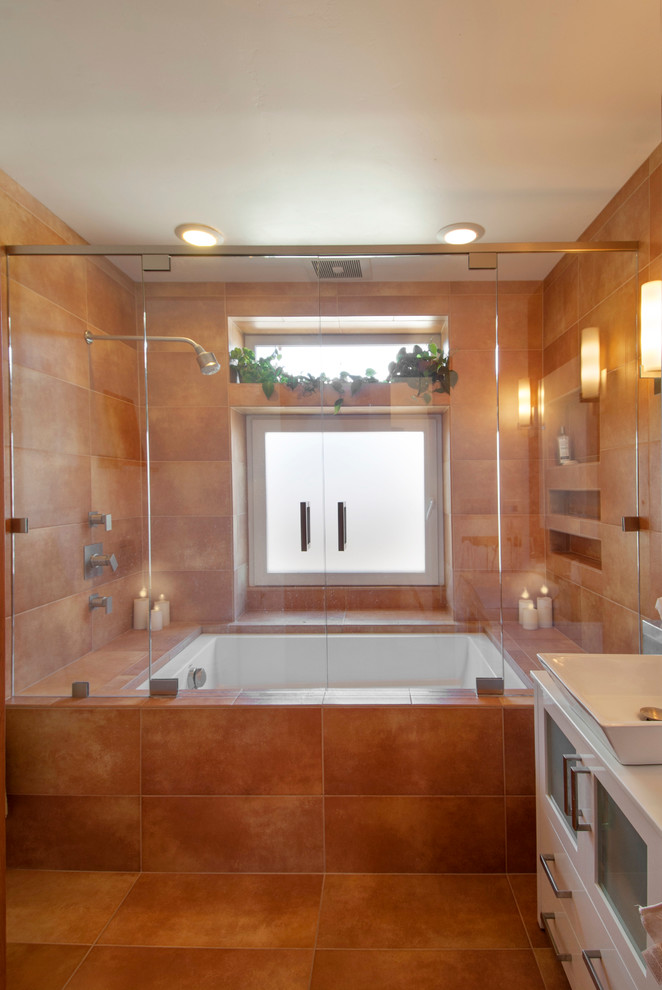 Пример оригинального дизайна: ванная комната среднего размера в современном стиле с настольной раковиной, стеклянными фасадами, белыми фасадами, полновстраиваемой ванной, душем над ванной, унитазом-моноблоком, разноцветной плиткой, керамической плиткой и полом из керамической плитки