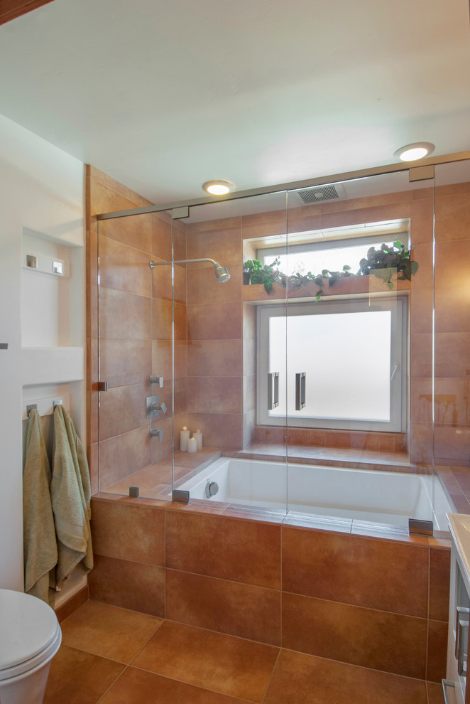 Tub/shower combo - mid-sized contemporary master multicolored tile and ceramic tile ceramic tile tub/shower combo idea in San Francisco with a vessel sink, glass-front cabinets, white cabinets, an undermount tub and a one-piece toilet
