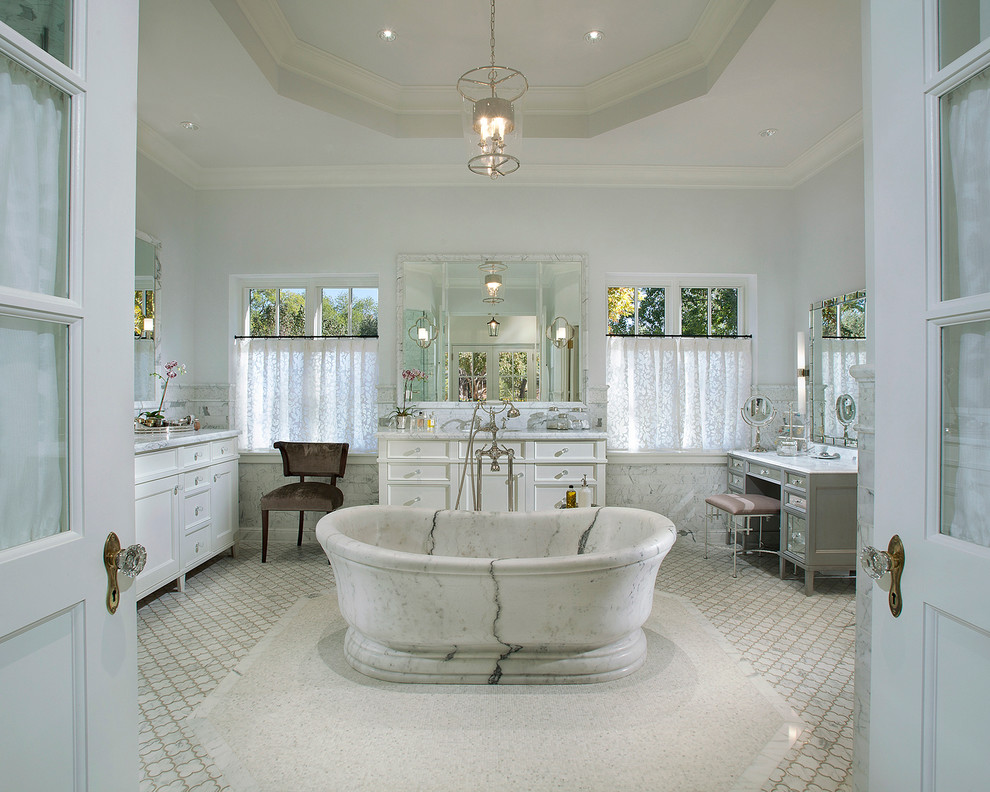 Ispirazione per una stanza da bagno chic con ante con riquadro incassato, ante bianche, vasca freestanding e piastrelle bianche