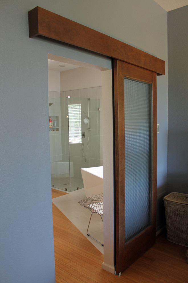 Foto på ett mellanstort funkis en-suite badrum, med ett fristående badkar, en kantlös dusch, grå kakel, porslinskakel, grå väggar, bambugolv, grått golv och dusch med gångjärnsdörr