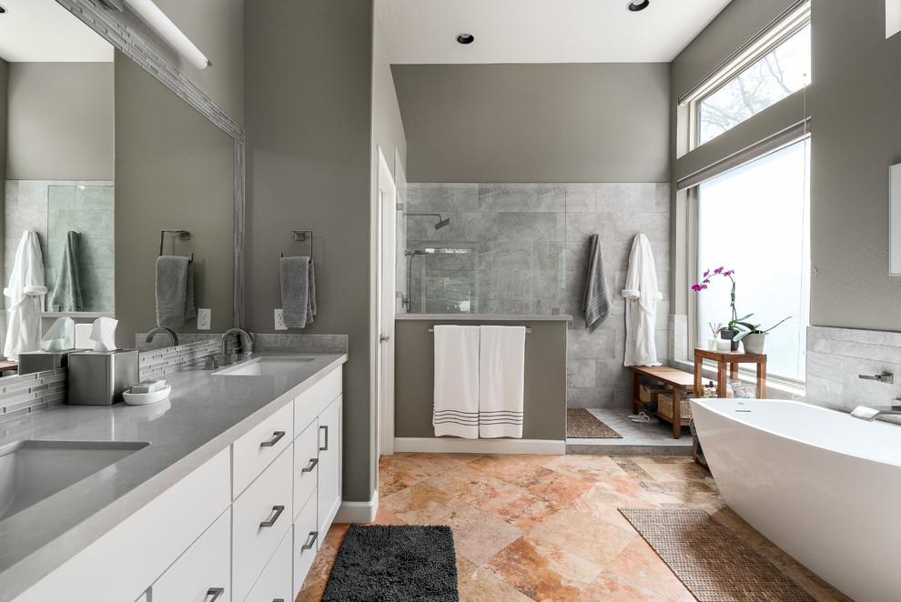 Photo of a medium sized modern ensuite bathroom in Phoenix with beaded cabinets, white cabinets, a freestanding bath, a walk-in shower, a one-piece toilet, grey tiles, cement tiles, beige walls, ceramic flooring, an integrated sink, marble worktops, multi-coloured floors, an open shower and grey worktops.