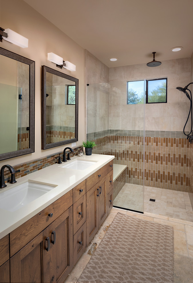 Idées déco pour une salle de bain sud-ouest américain en bois brun avec un placard avec porte à panneau encastré, une douche à l'italienne, un carrelage beige, un carrelage marron, un carrelage gris, un mur beige, un lavabo encastré, un sol beige, un plan de toilette beige et une fenêtre.