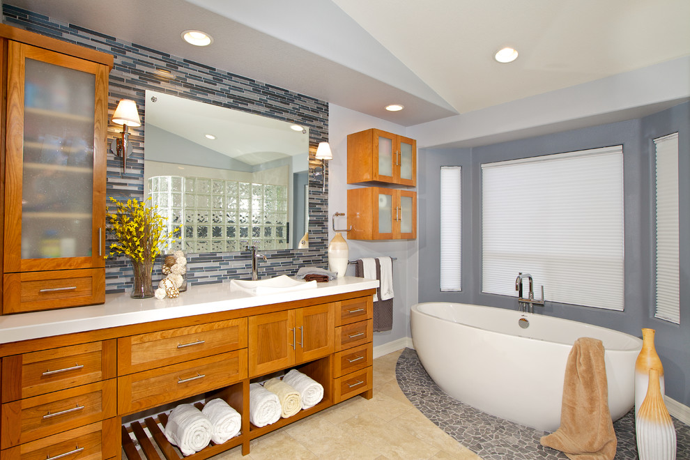 Foto di una stanza da bagno chic con lavabo da incasso, consolle stile comò, ante in legno scuro, top in superficie solida, vasca freestanding e piastrelle blu