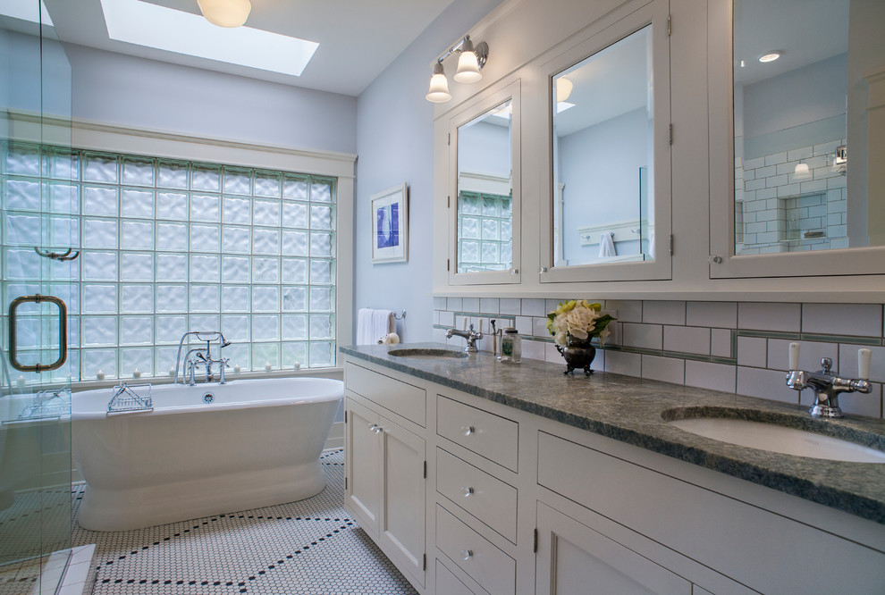 Bild på ett mellanstort amerikanskt en-suite badrum, med ett undermonterad handfat, skåp i shakerstil, vita skåp, granitbänkskiva, ett fristående badkar, en dubbeldusch, vit kakel, tunnelbanekakel, grå väggar och mosaikgolv