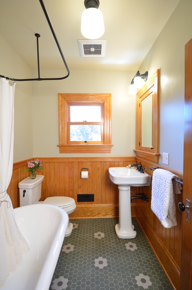Kleines Landhaus Badezimmer mit Sockelwaschbecken, hellbraunen Holzschränken, Löwenfuß-Badewanne, Wandtoilette mit Spülkasten, beiger Wandfarbe und braunem Holzboden in Portland