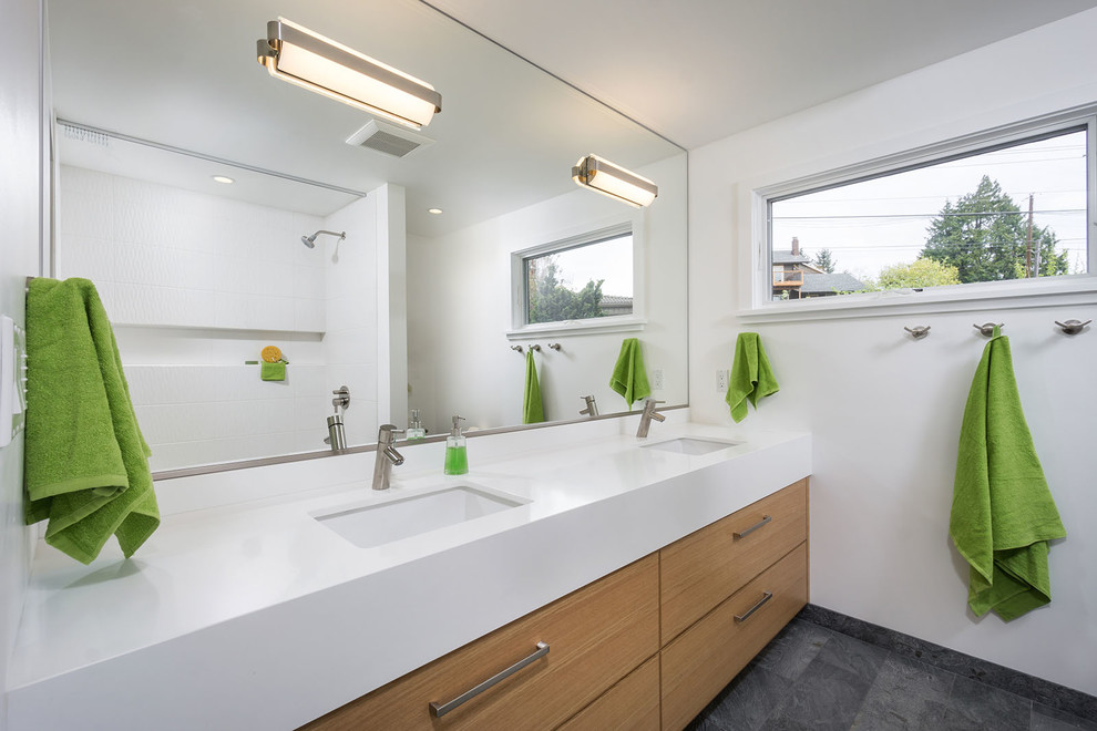 Ispirazione per una stanza da bagno minimal con lavabo sottopiano, ante lisce, ante in legno scuro e pareti bianche