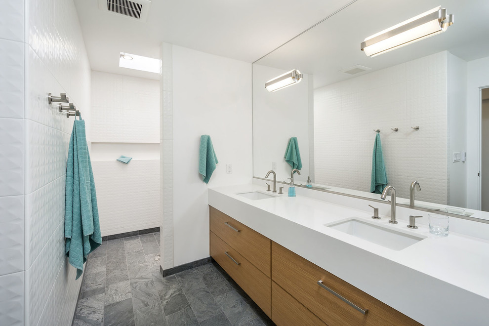 Foto di una stanza da bagno minimal con lavabo sottopiano, ante lisce, ante in legno scuro, doccia aperta, piastrelle bianche, pareti bianche e doccia aperta