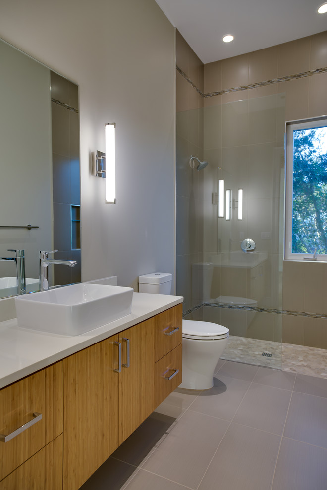 Cette photo montre une salle de bain tendance en bois brun de taille moyenne avec un placard à porte plane, une douche à l'italienne, WC séparés, un carrelage marron, des carreaux de porcelaine, un mur beige, un sol en carrelage de porcelaine, une vasque et un plan de toilette en quartz modifié.