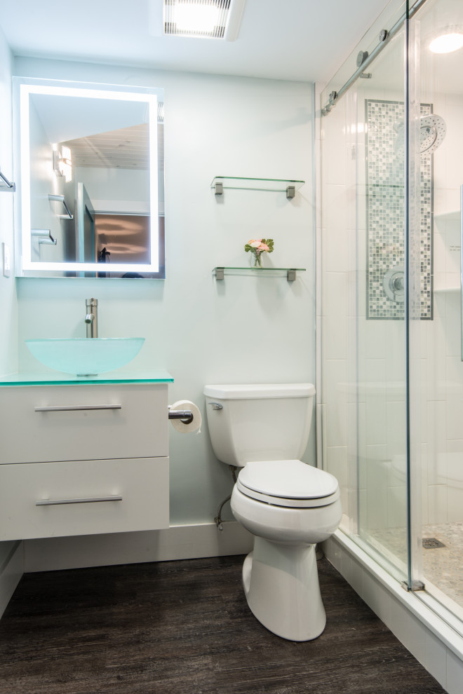 Стильный дизайн: ванная комната среднего размера в современном стиле с плоскими фасадами, белыми фасадами, душем в нише, раздельным унитазом, полом из винила, душевой кабиной, настольной раковиной, стеклянной столешницей и душем с раздвижными дверями - последний тренд