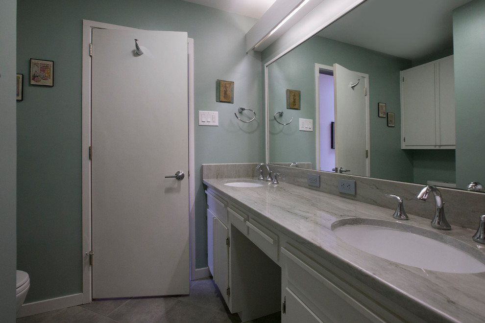 Photo of a medium sized traditional family bathroom in Raleigh with flat-panel cabinets, white cabinets, an alcove bath, a shower/bath combination, a two-piece toilet, grey tiles, porcelain tiles, green walls, porcelain flooring, a submerged sink, quartz worktops, grey floors, a sliding door and grey worktops.