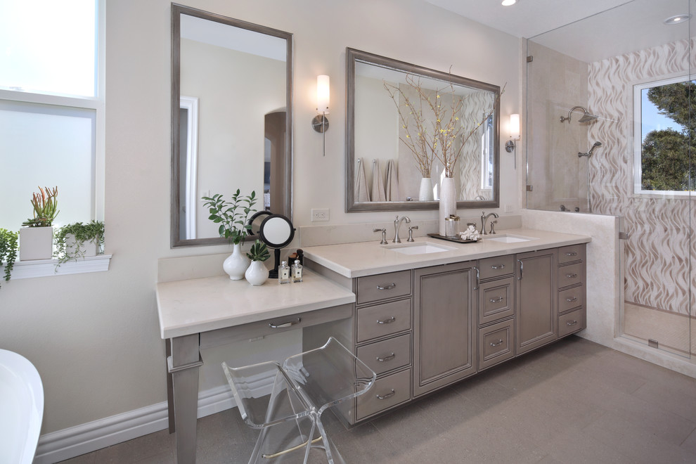 Bathroom - mid-sized transitional master stone tile beige floor and ceramic tile bathroom idea in Orange County with gray cabinets, a two-piece toilet, beige walls, quartz countertops, a hinged shower door, recessed-panel cabinets and a drop-in sink