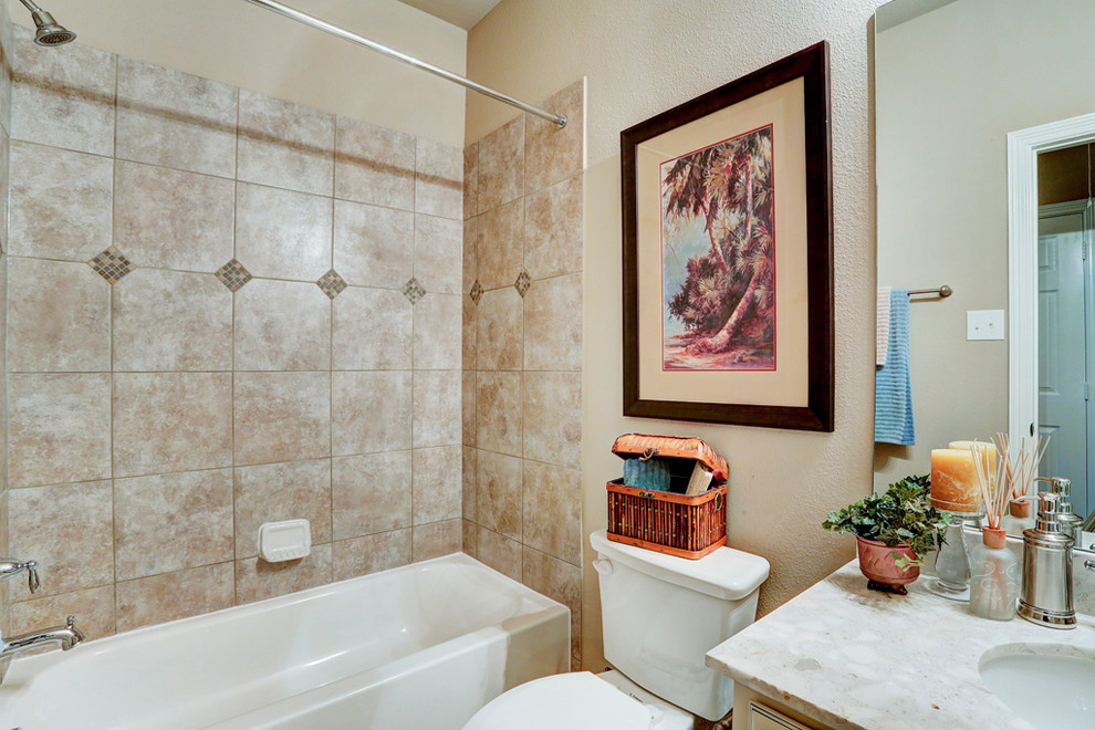 Example of a large classic kids' beige tile and ceramic tile ceramic tile bathroom design in Houston with recessed-panel cabinets, white cabinets, a two-piece toilet, beige walls, an undermount sink and solid surface countertops