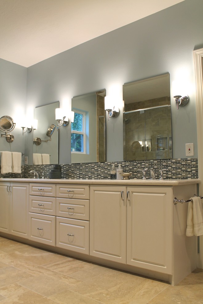 Immagine di una grande stanza da bagno padronale chic con lavabo sottopiano, ante con bugna sagomata, ante bianche, top in superficie solida, piastrelle beige, piastrelle in gres porcellanato, pareti blu e pavimento in gres porcellanato
