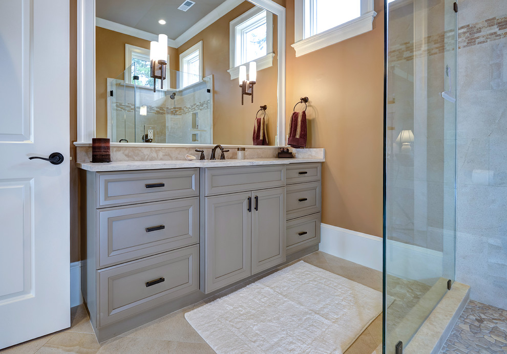 Aménagement d'une grande salle de bain classique avec des portes de placard grises, une douche d'angle, un mur jaune, un lavabo encastré, un sol beige, une cabine de douche à porte battante, un plan de toilette blanc, meuble simple vasque et meuble-lavabo encastré.