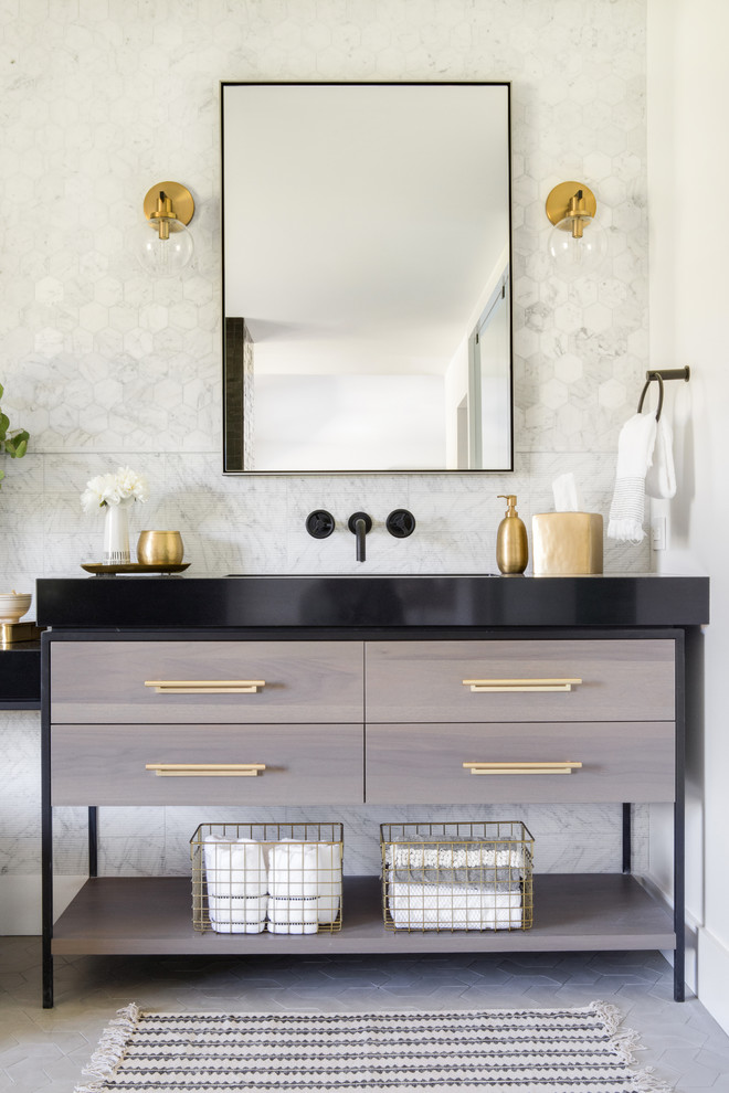 Modernes Badezimmer mit flächenbündigen Schrankfronten, grauen Schränken, grauen Fliesen, grauer Wandfarbe, Waschtischkonsole, grauem Boden und schwarzer Waschtischplatte in Orange County