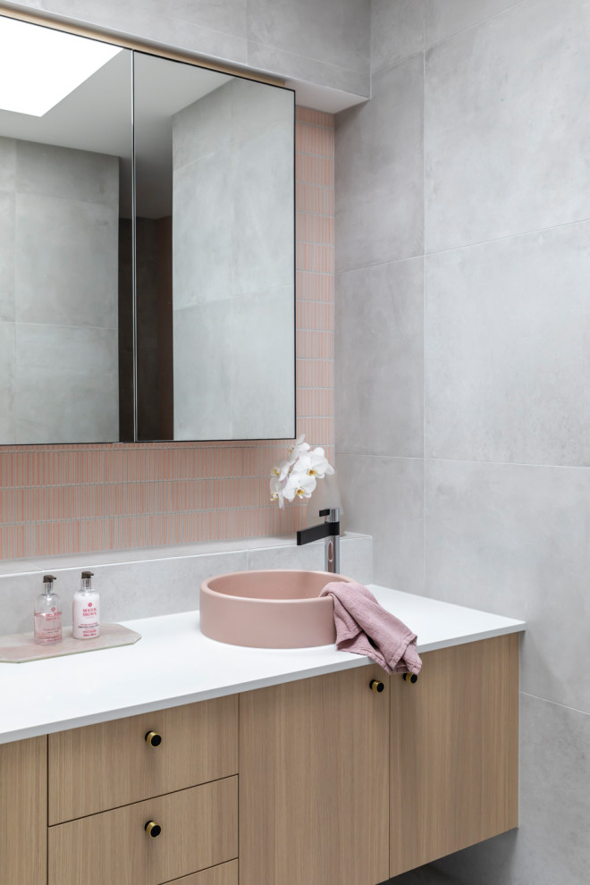Inspiration för ett funkis vit vitt badrum, med släta luckor, skåp i ljust trä, rosa kakel, mosaik och ett fristående handfat