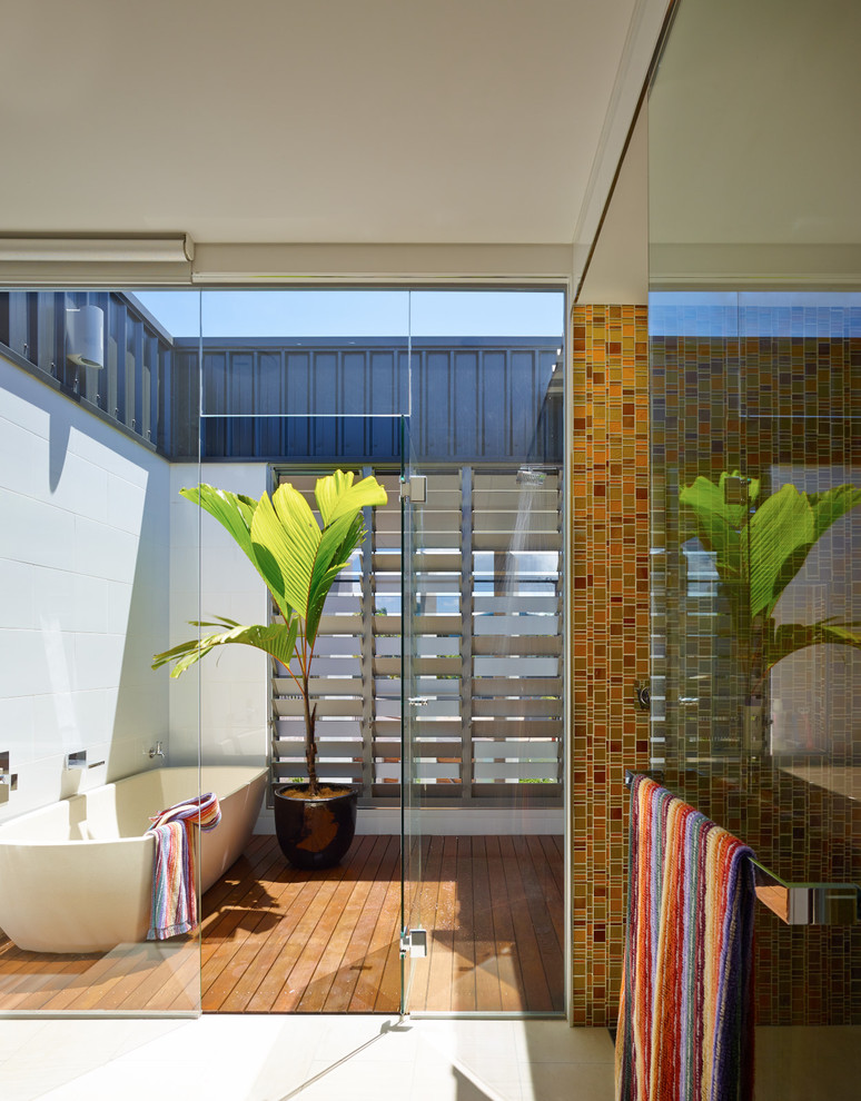 Modern inredning av ett stort en-suite badrum, med ett fristående badkar, vit kakel, keramikplattor, vita väggar, mellanmörkt trägolv och en öppen dusch