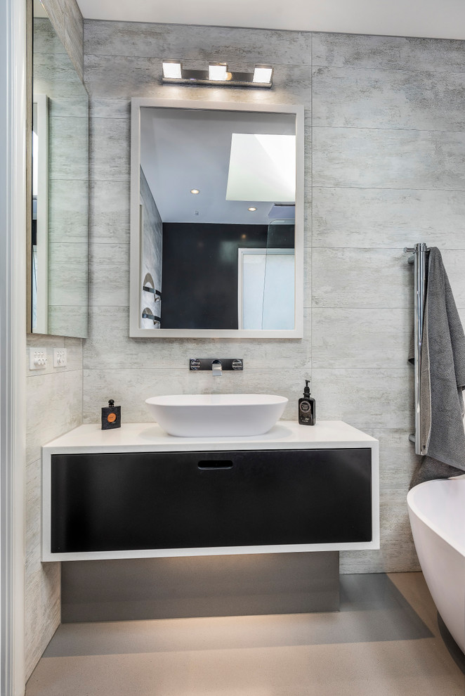 Idées déco pour une petite salle de bain contemporaine avec des portes de placard noires, une baignoire indépendante, une douche ouverte, un plan de toilette en surface solide, meuble simple vasque et meuble-lavabo suspendu.