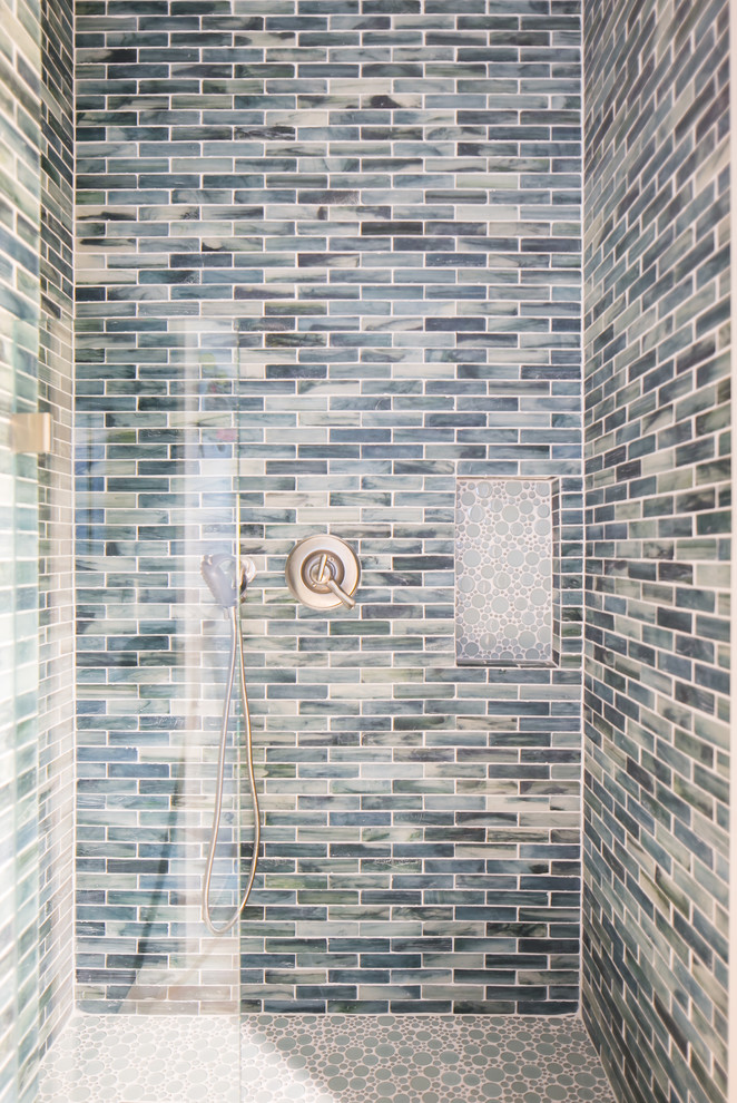 Cette image montre une petite salle d'eau marine avec un placard à porte shaker, des portes de placard blanches, une douche ouverte, un carrelage bleu, un carrelage en pâte de verre, un mur gris, un sol en galet et un plan de toilette en marbre.